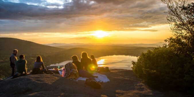 group of people sirring under sunset