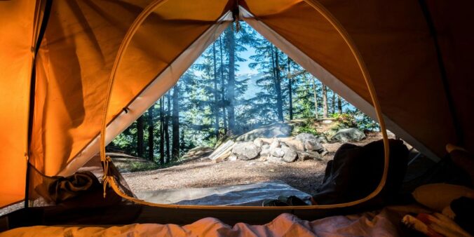 orange camping tent near green trees