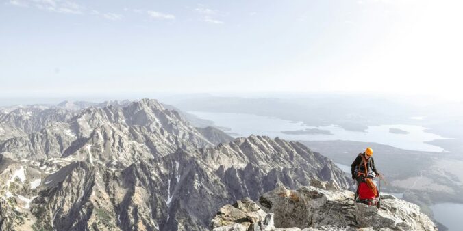 photo of man on top of mountain during daytime