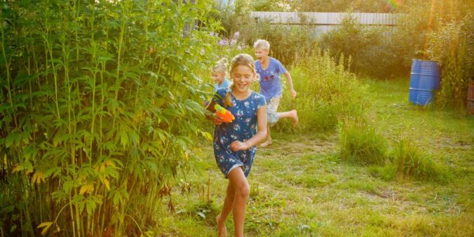 girl in blue and white shirt standing on green grass field during daytime